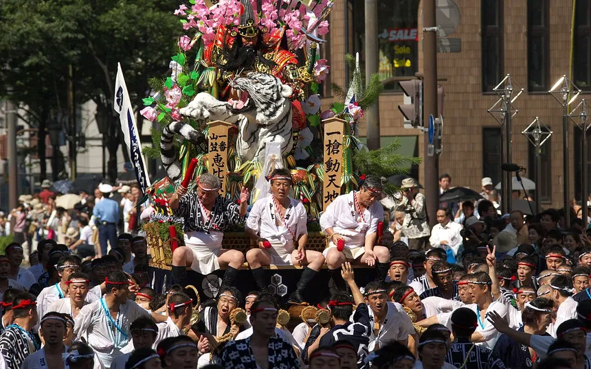 A racing float with riders aboard pushing through the crowd, July 2006