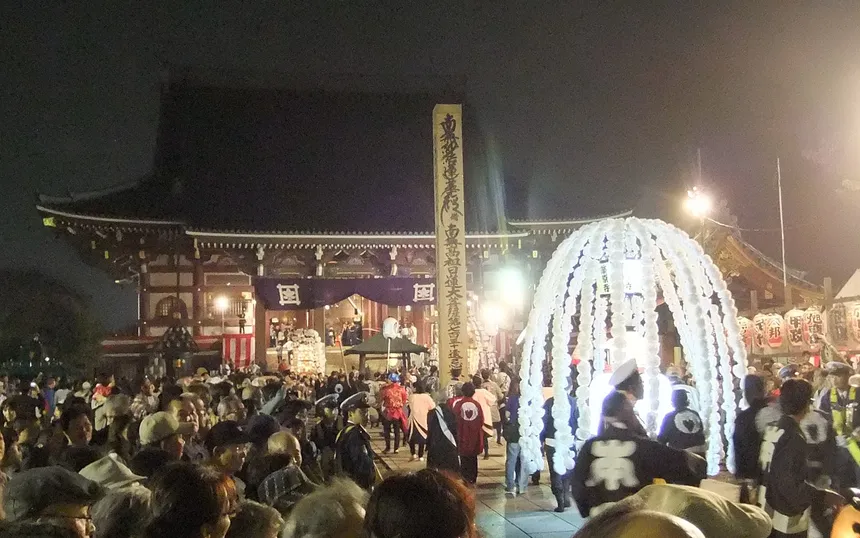 A mando lantern tower hung with paper blossom arrives before the main hall of Ikegami Honmon-ji, 2011